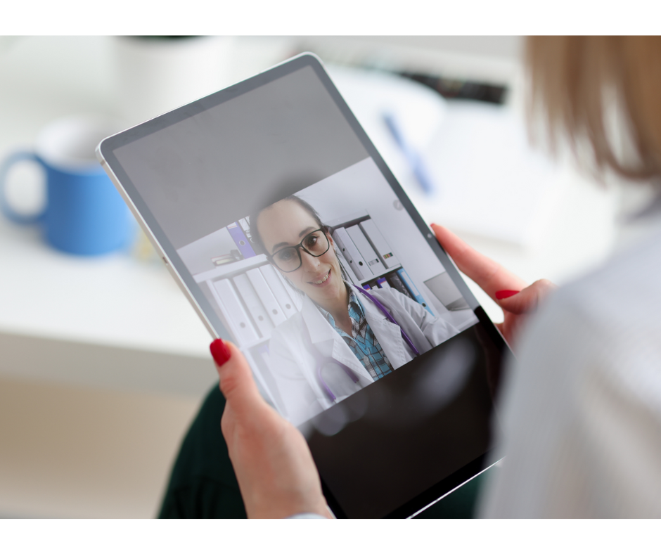 Patient holding iPad showing video consultation with healthcare professional