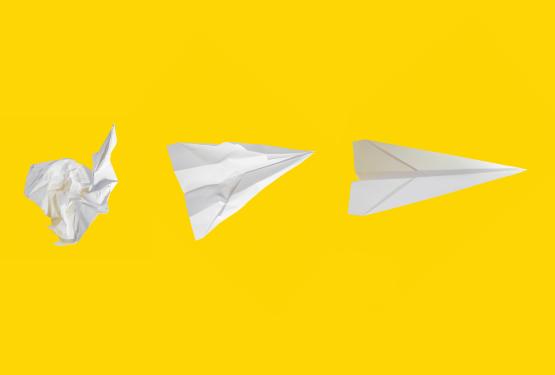 scrunched up paper turned into paper plane
