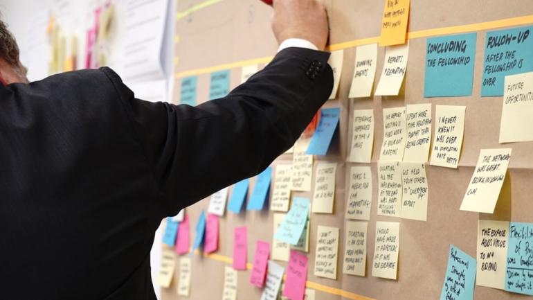 people in a workshop writing on post-its