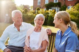 elderly couple laughing with nurse